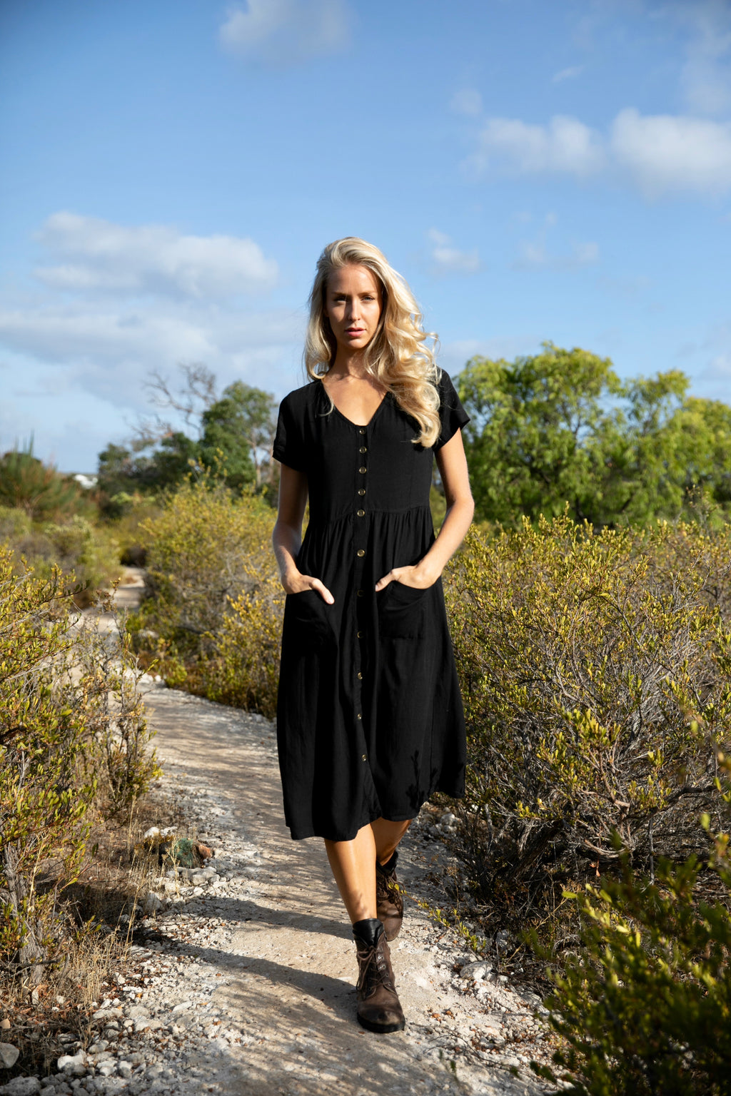 A modern bohemian midi length dress with a v neck and sleeves that button through front in black linen blend fabric at Jipsi Cartel a womens boho fashion and accessories online shop located in Wason Street Milton NSW