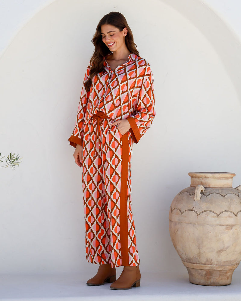 the arely pant by label of love are bright coloured pull on elastic waist pants in a geo print and contrast stripe down the side and part of a matching pant set