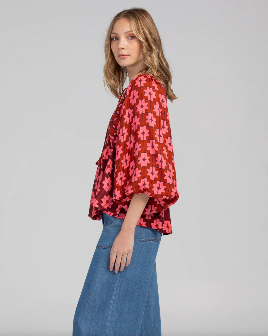 The noel top by boom shankar is a peasant style boho blouse with a pink and red retro geometric pattern and ballon sleeves