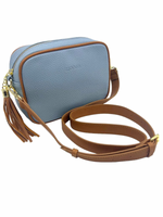 a light blue vegan leather cross body bag by zjoosh with tan contrast piping and straps