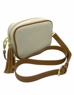 a ecru vegan leather cross body bag by zjoosh with tan contrast piping and straps