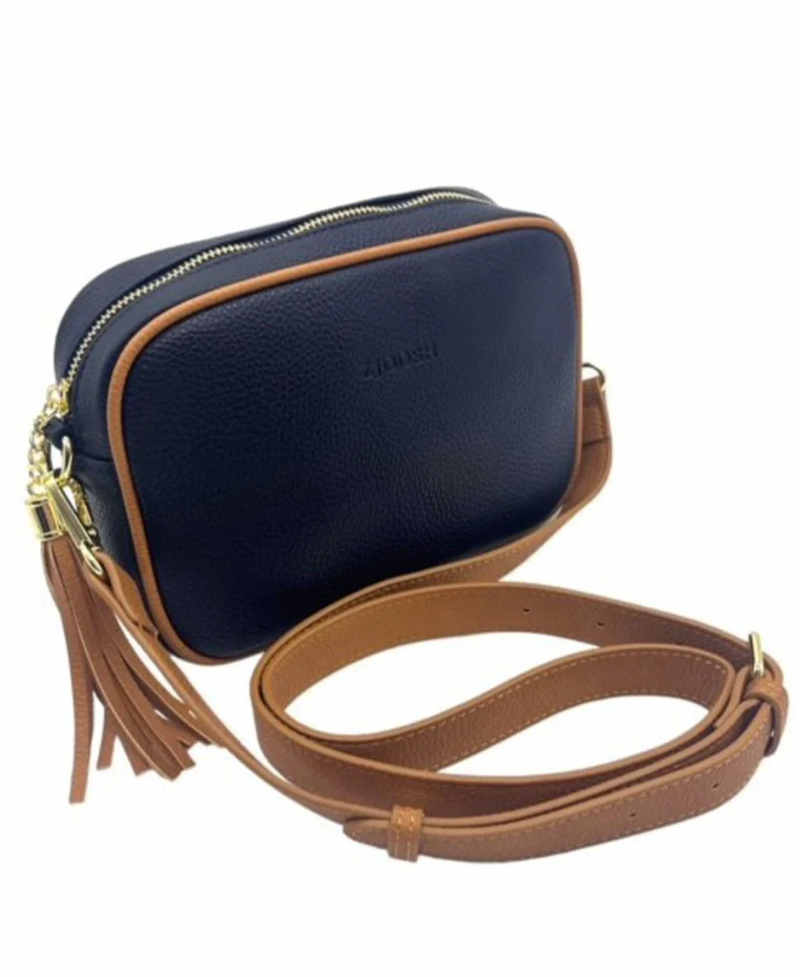 a navy blue vegan leather cross body bag by zjoosh with tan contrast piping and straps