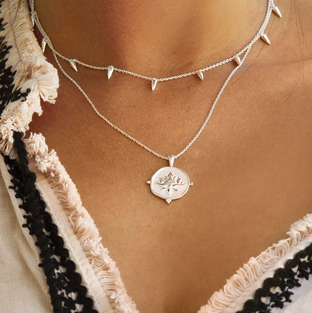 a sterling silver necklace with a blooming lotus design pendant