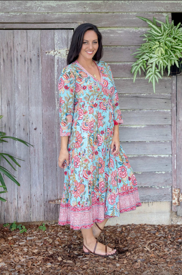 the genevieve dress is a soft cotton hand block printed midi length wrap dress in a blue and pink floral design by soul song